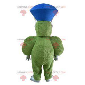 Mascote monstro verde peludo e gordo muito sorridente -