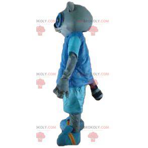 Graues Katzenmaskottchen im blauen Outfit mit Brille -