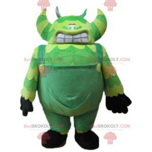 Mascot green monster in overalls very big and funny -