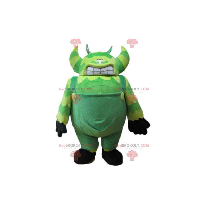 Maskot zelené monstrum ve velmi velkých a vtipných kombinézách