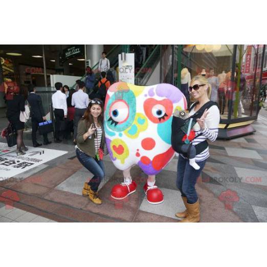 Mascote gigante com dente branco manchado de cores -
