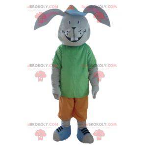 Grijs konijn mascotte lachend met een kleurrijke outfit -