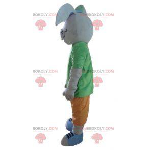 Graues Kaninchenmaskottchen, das mit einem bunten Outfit
