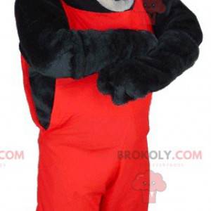 Maskottchen schwarzer und grauer Wolf in roten Overalls -