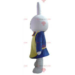 Bílý králík maskot oblečený v modré barvě se zástěrou -