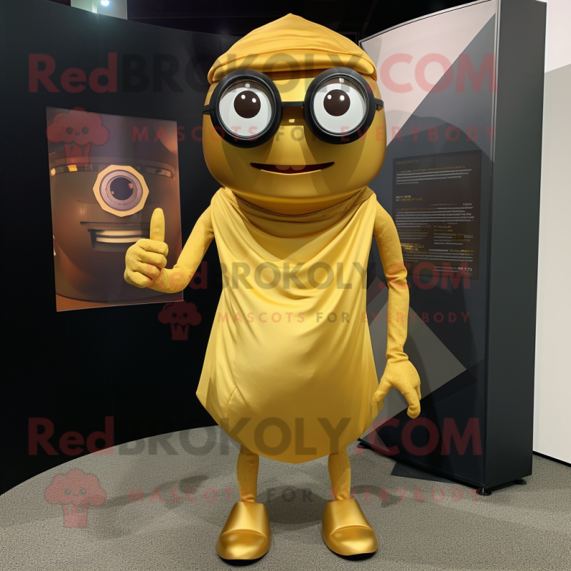 Gold Cyclops mascot costume character dressed with a Wrap Skirt and Eyeglasses Gold Cyclops mascot costume character dressed with a Wrap Skirt and Eyeglasses