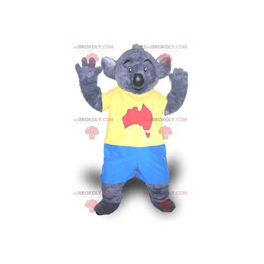 Graues Koalamaskottchen im blauen und gelben Outfit -