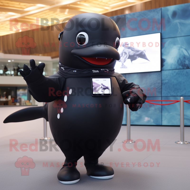 Black Humpback Whale mascot costume character dressed with a T-Shirt and Smartwatches