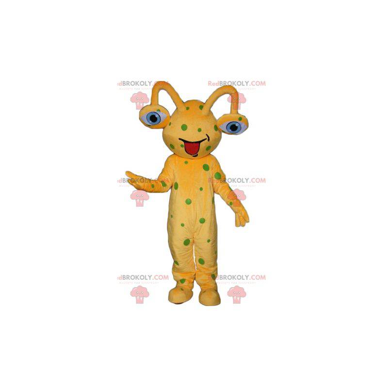 Mascota alienígena amarilla con guisantes verdes -