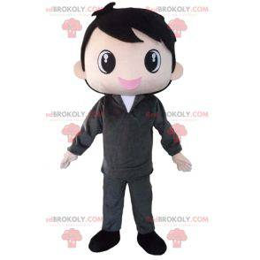 Brown mascotte ragazzo vestito di grigio molto sorridente -