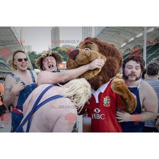 Brun lejonmaskot alla håriga i röda sportkläder - Redbrokoly.com