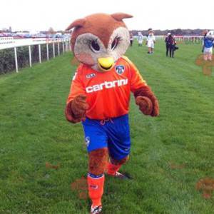 Bruine en witte uilen mascotte in oranje en blauwe outfit -