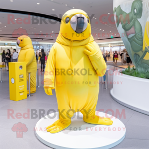 Personaje de disfraz de mascota de morsa amarillo limón vestido con mono y boinas