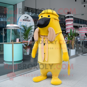 Personaje de disfraz de mascota de morsa amarillo limón vestido con mono y boinas