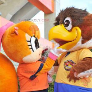 2 mascotes, um grande pássaro marrom e um esquilo laranja -