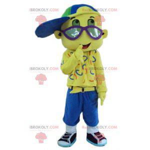 Geheel gele jongen mascotte met een pet en een bril -