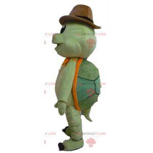 Mascota tortuga verde y naranja con sombrero de vaquero -
