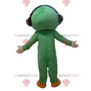 Mascotte d'homme en combinaison verte avec un casque audio -