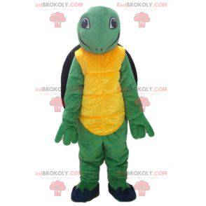 Simpática e sorridente mascote tartaruga amarela verde e preta