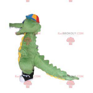 Groen en geel krokodil mascotte met een pet - Redbrokoly.com