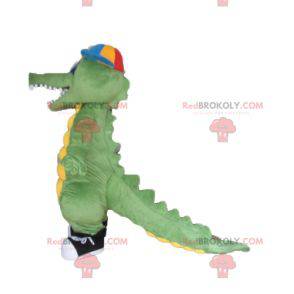 Mascotte coccodrillo verde e giallo con un berretto -
