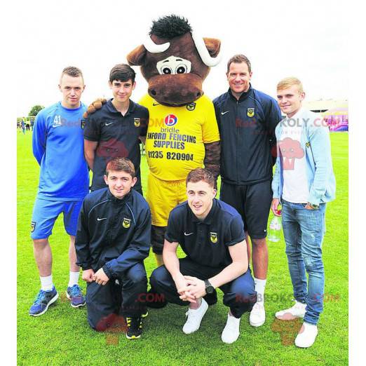 Brun ko maskot i gul sportkläder - Redbrokoly.com