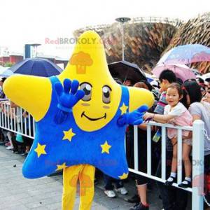 Mascote estrela gigante amarela com uma roupa azul