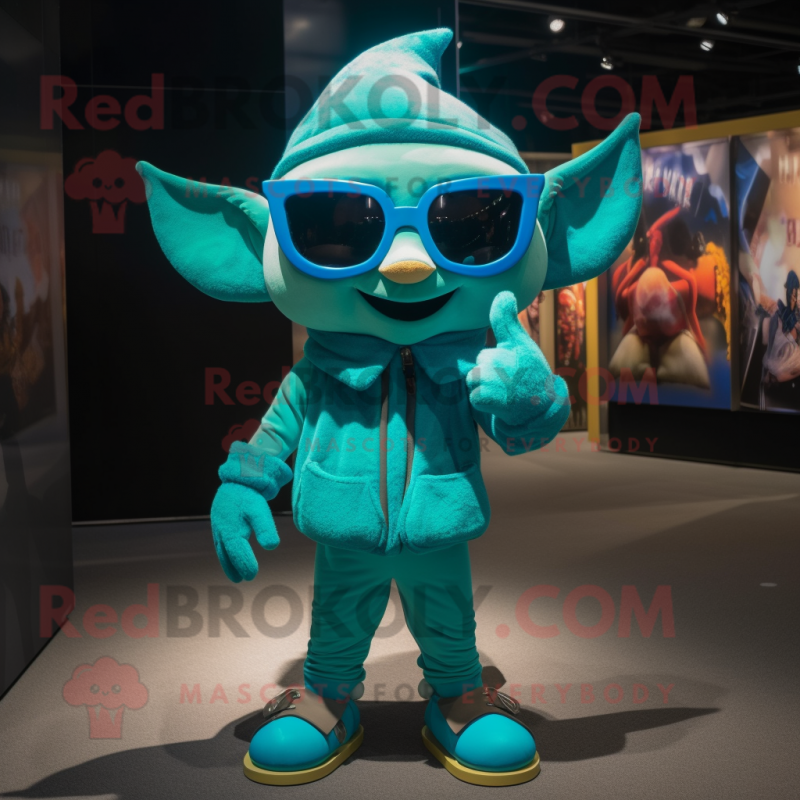 Turquoise Elf mascot costume character dressed with a Jumpsuit and Sunglasses Turquoise Elf mascot costume character dressed with a Jumpsuit and Sunglasses