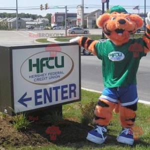 Orange and black tiger mascot in green and blue outfit -