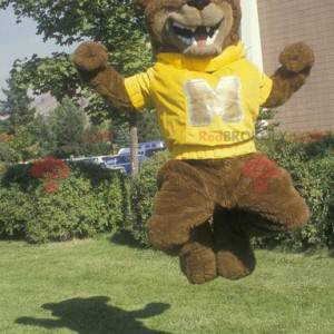 Mascote urso pardo com um moletom amarelo - Redbrokoly.com