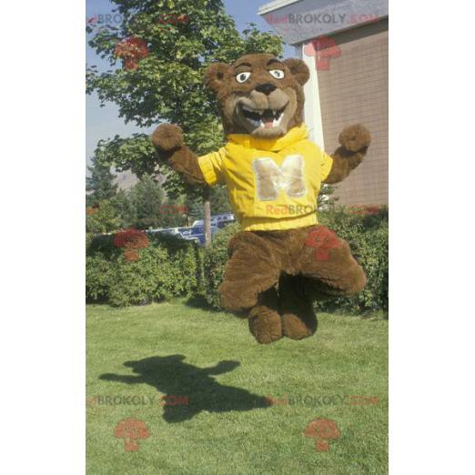 Brun björnmaskot med en gul tröja - Redbrokoly.com