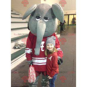 Gray and funny elephant mascot in red sportswear -