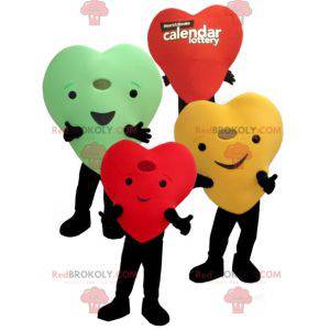 3 mascotes gigantes e sorridentes com corações coloridos -