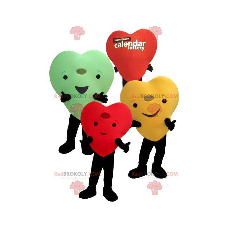 3 mascottes de cœurs colorés géants et souriants -