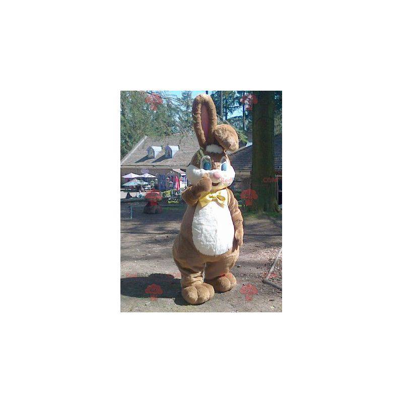 Mascot groot bruin en wit konijn met een vlinderdas -