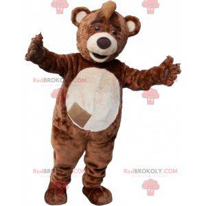 Brown and beige teddy bear mascot with a crest on the head -