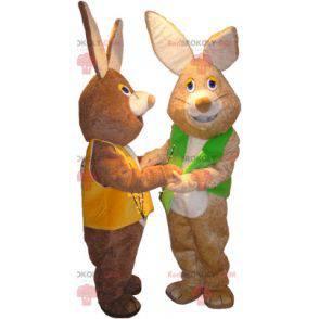 2 mascots of brown and white rabbits with colored vests -