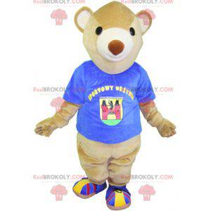Mascote do ursinho de pelúcia bege com uma camiseta azul -
