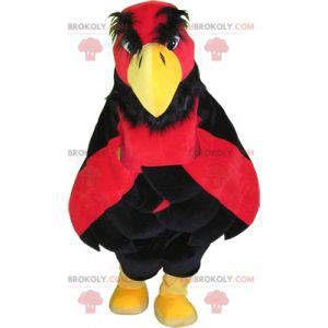 Mascota águila roja y amarilla con pantalón negro -