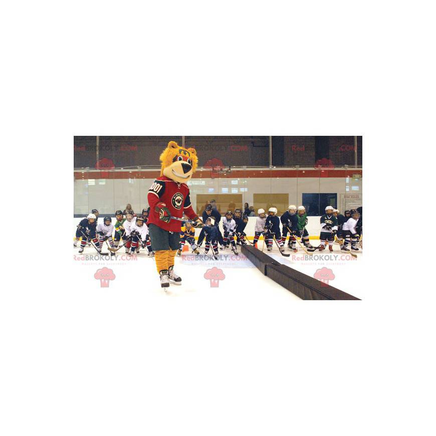 Mascotte dell'orso arancione in attrezzatura da hockey -