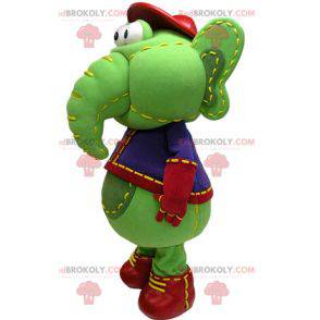 Mascote elefante verde e amarelo em traje azul e vermelho -