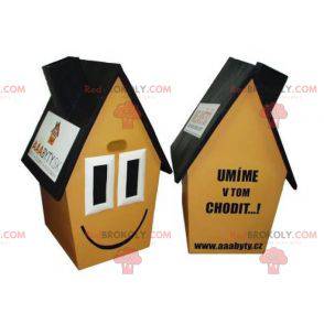 Mascotte de maison jaune marron et noire très souriante -