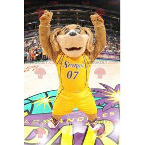 Brązowy pies maskotka w żółtej odzieży sportowej -