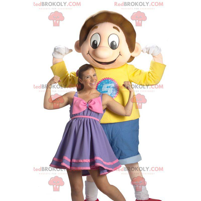Mascotte de garçon d’écolier souriant habillé en bleu et jaune Mascotte de garçon d’écolier souriant habillé en bleu et jaune