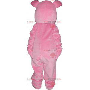 Rosa Schweinemaskottchen mit einer orange Karotte -