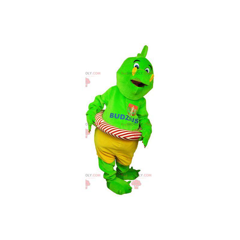 Mascota dinosaurio verde llamativo en pantalones cortos con una