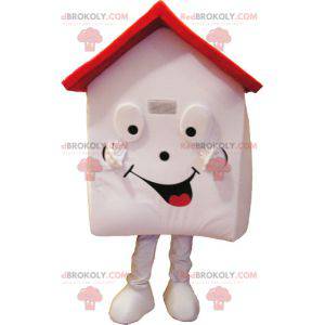 Mascotte de maison blanche et rouge très souriante -