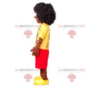 Afrikaanse jongen mascotte met een gele en rode outfit -