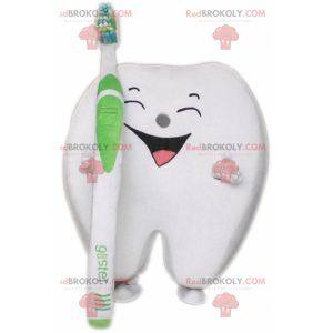Mascotte gigante del dente bianco con uno spazzolino da denti -