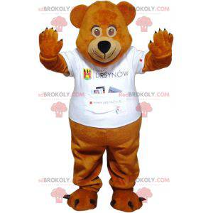 Mascotte dell'orsacchiotto marrone con una maglietta bianca -